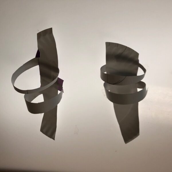 A pair of sandals made from slices of a plate with straps.
