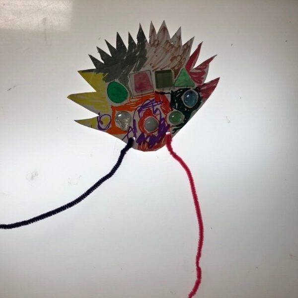 A tiara cut out from a paper plate, complete with jewels and a headband.